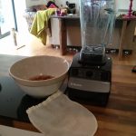 Equipment to make almond milk: blender, bowl of soaking almonds and a nut bag.