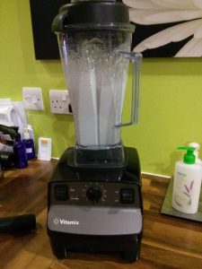 Vitamix blender on counter blending almond milk.