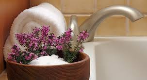 epsom salts in a bowl with fresh lavendar, sitting on the edge of a bath.